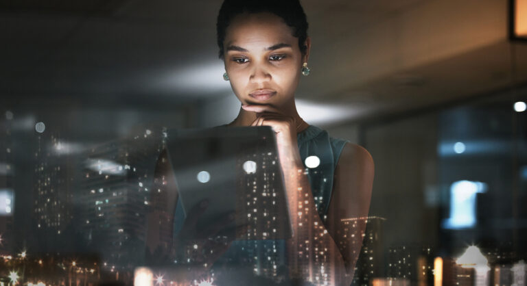 Person looking on their iPad with the reflection of the city through the window